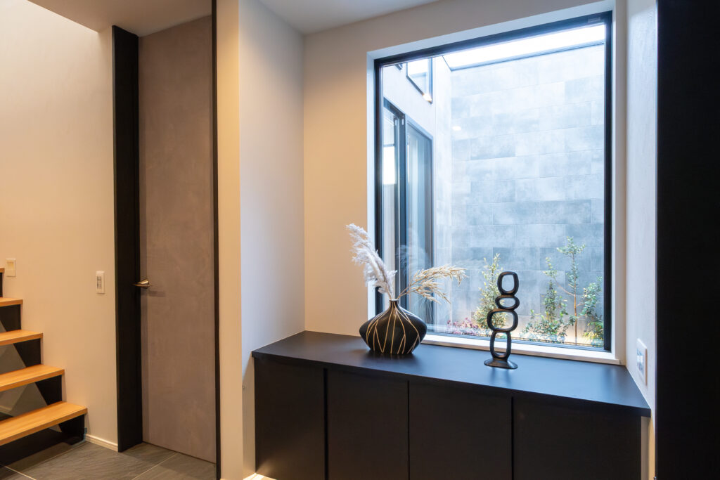 玄関ホールから望む、タイル仕上げの坪庭風の中庭